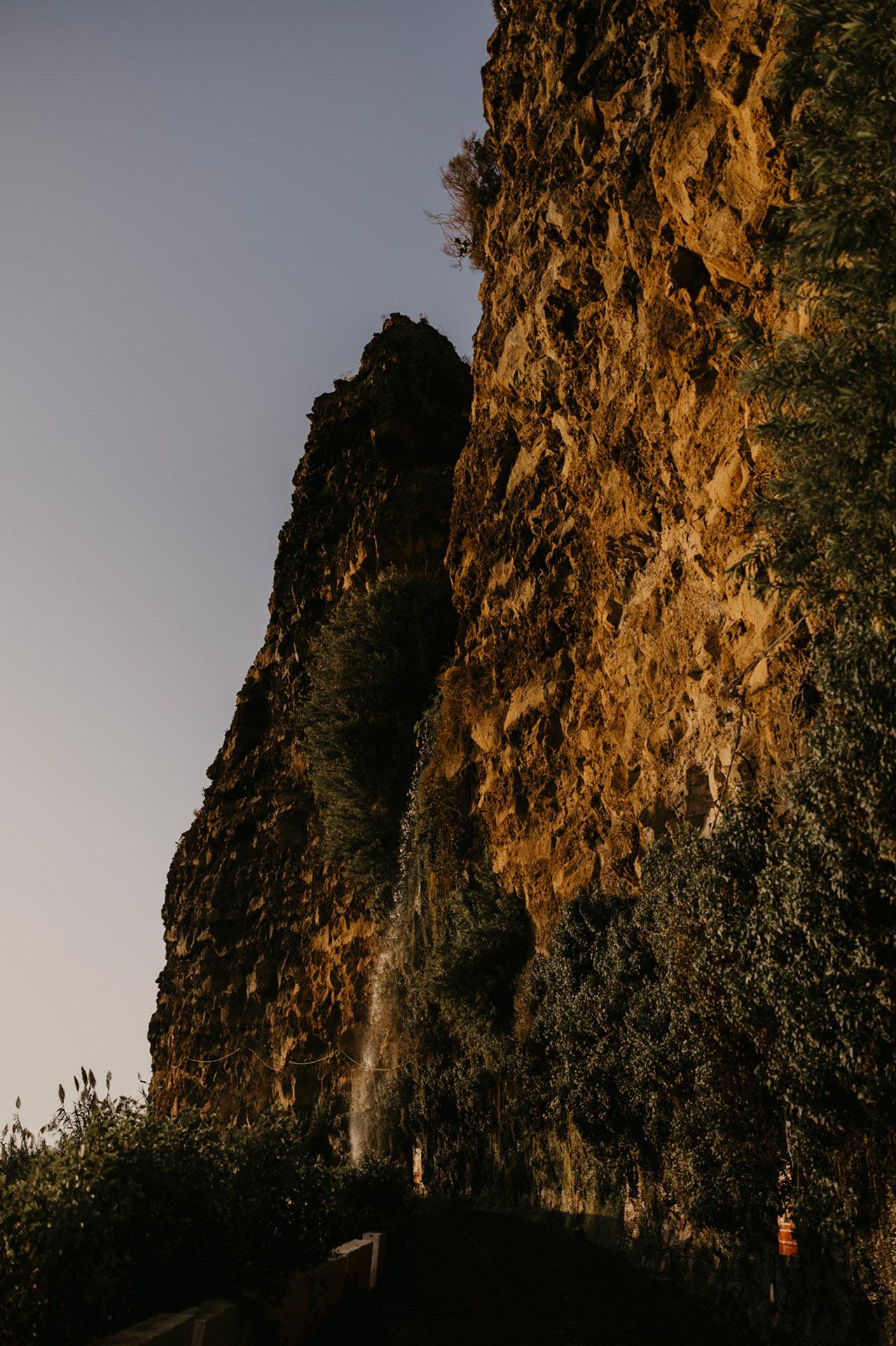 dospad Cascata dos Anjos spływający po skalistym klifie na Maderze, obrośnięty zielenią, naturalny krajobraz by Camera Folks Wedding Photo & Video